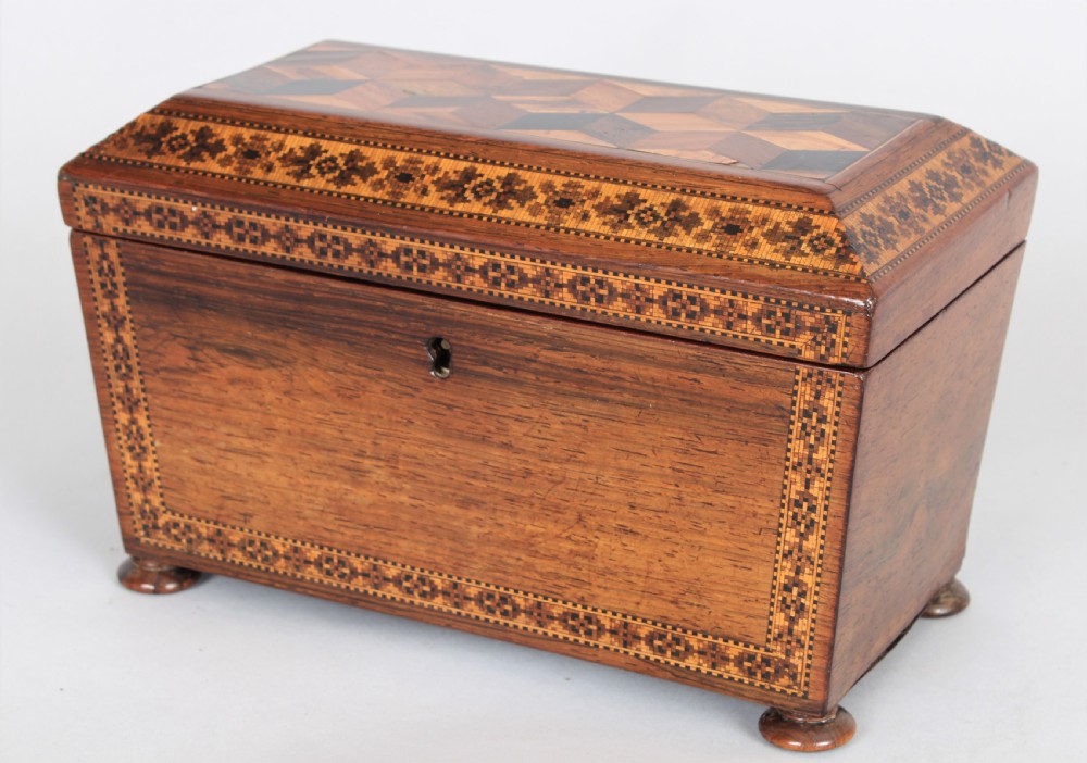 An antique rosewood tea caddy featuring geometric parquetry on the lid, detailed floral mosaic borders, a keyhole, and turned feet. View IV