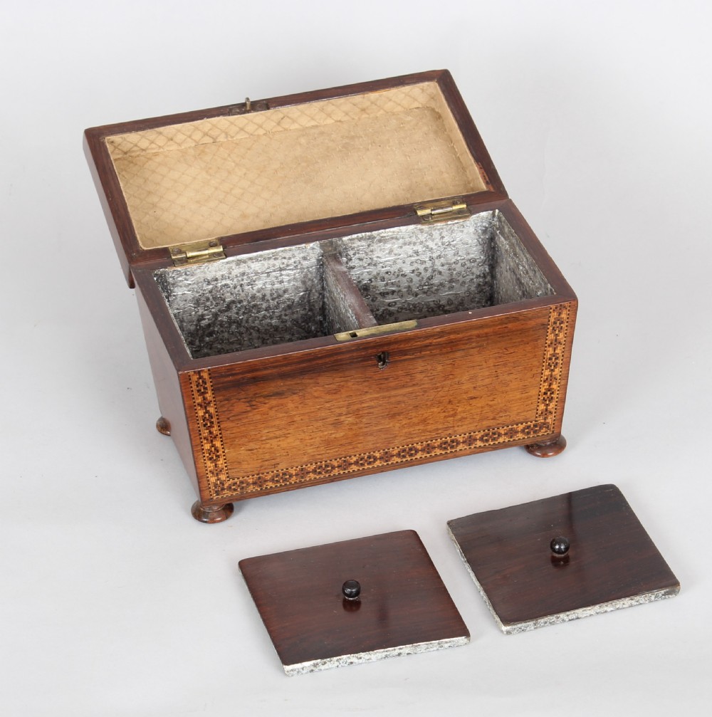 An antique rosewood tea caddy featuring geometric parquetry on the lid, detailed floral mosaic borders, a keyhole, and turned feet. View V