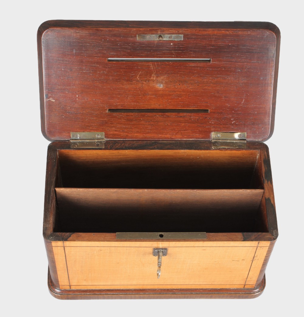 A rectangular 19th-century French wooden box with figured timber veneer, dual lid slots, central brass ring handle, metal corner mounts, and a key inserted in the front lock. View IV