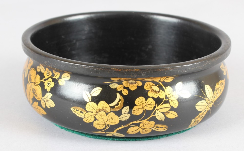 A pair of circular Victorian black lacquer papier-mache bottle coasters featuring hand-painted gold floral foliage. View II