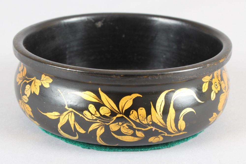 A pair of circular Victorian black lacquer papier-mache bottle coasters featuring hand-painted gold floral foliage. View III