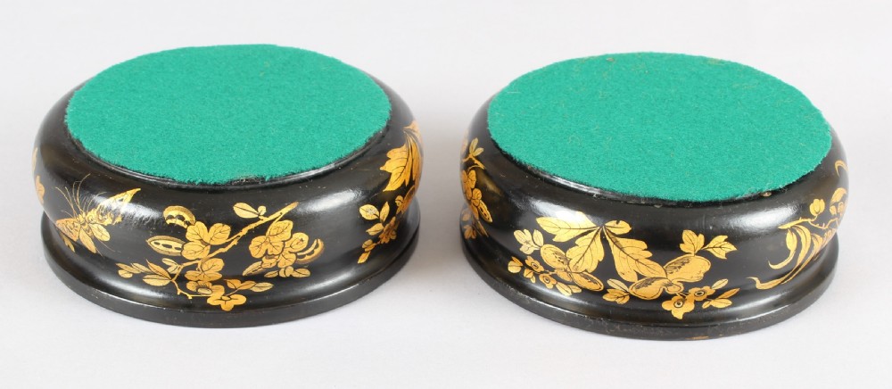 A pair of circular Victorian black lacquer papier-mache bottle coasters featuring hand-painted gold floral foliage. View IV