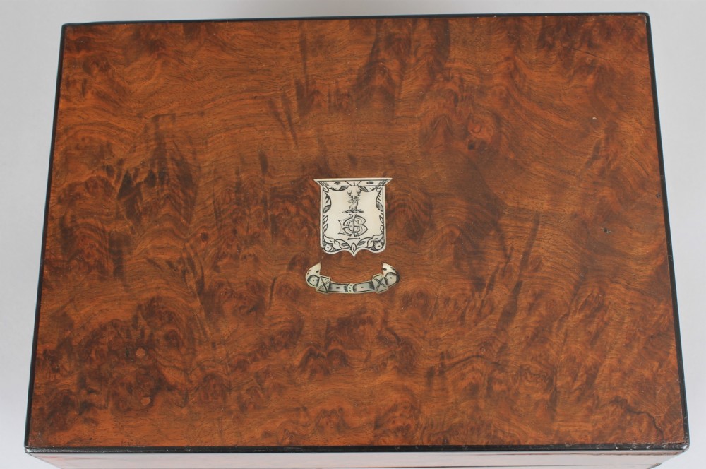 A rectangular Victorian burr walnut dressing box featuring a lockable lid, silver escutcheon, and inlaid top cartouche against a plain background. View III
