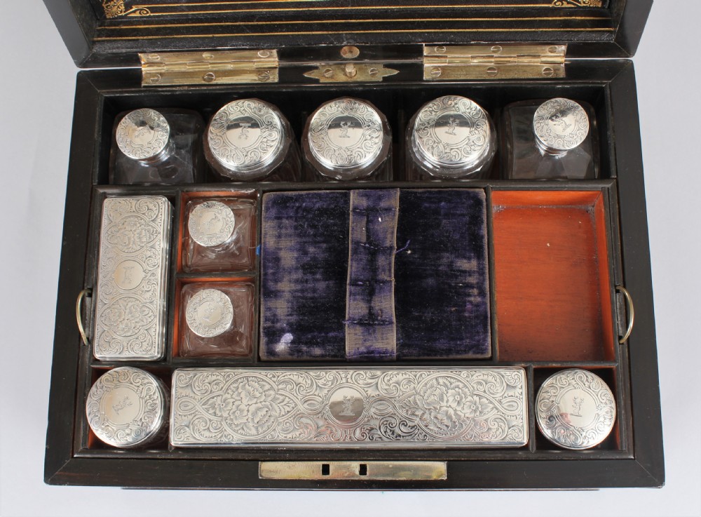 A rectangular Victorian burr walnut dressing box featuring a lockable lid, silver escutcheon, and inlaid top cartouche against a plain background. View VII