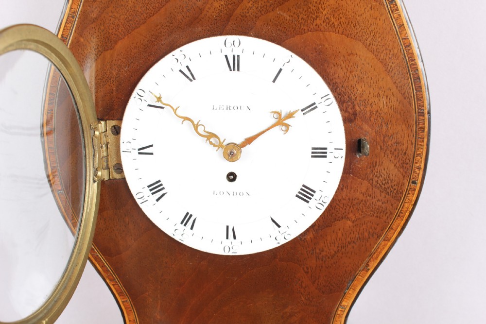 A George IV mahogany wheel barometer featuring silvered dials, an integrated clock, thermometer, and brass bezel details. View III