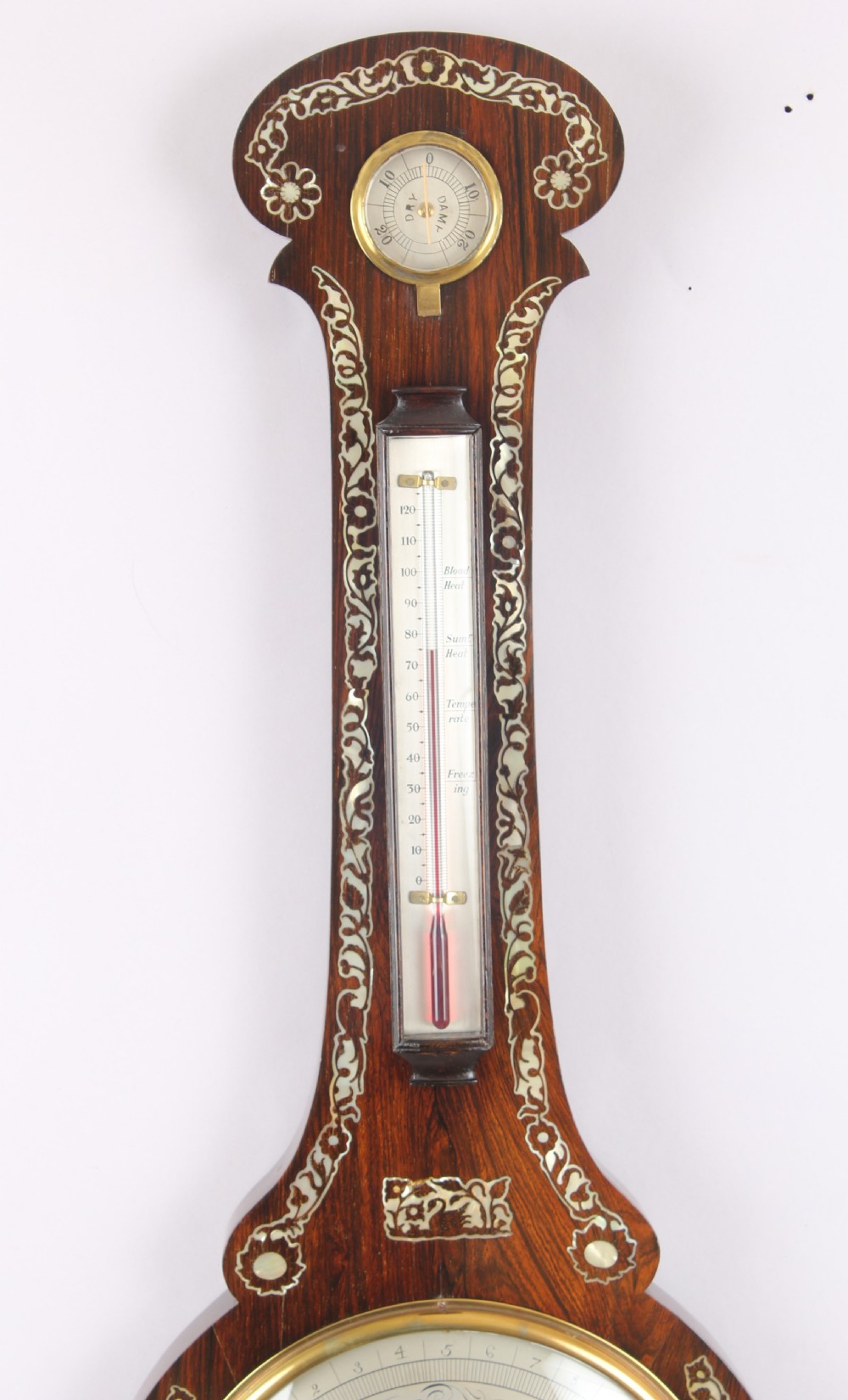 A Victorian rosewood banjo wheel barometer decorated with mother-of-pearl floral inlays, featuring a central thermometer and silvered weather dial. View IV