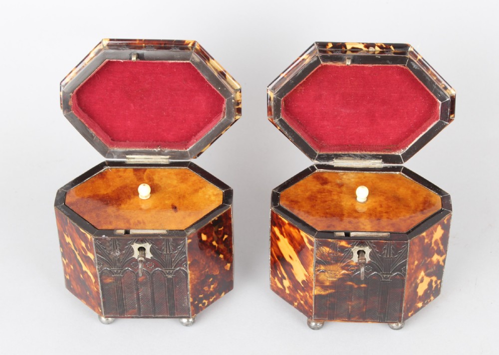 A pair of octagonal George IV period miniature tea caddies crafted with mottled tortoiseshell veneer, silver urn finials, ball feet, and gothic arcading. View III