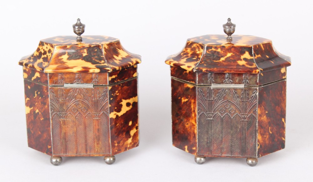 A pair of octagonal George IV period miniature tea caddies crafted with mottled tortoiseshell veneer, silver urn finials, ball feet, and gothic arcading. View VI