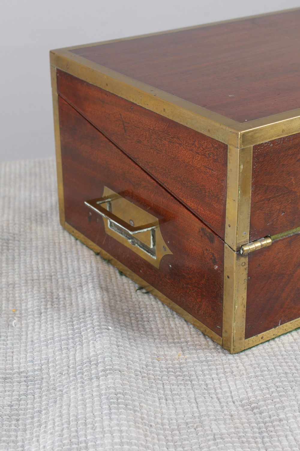 An open antique mahogany writing box with brass corner mounts, revealing a green baize writing surface, internal pen tray compartments, and a stationers paper label inside the lid. View VI