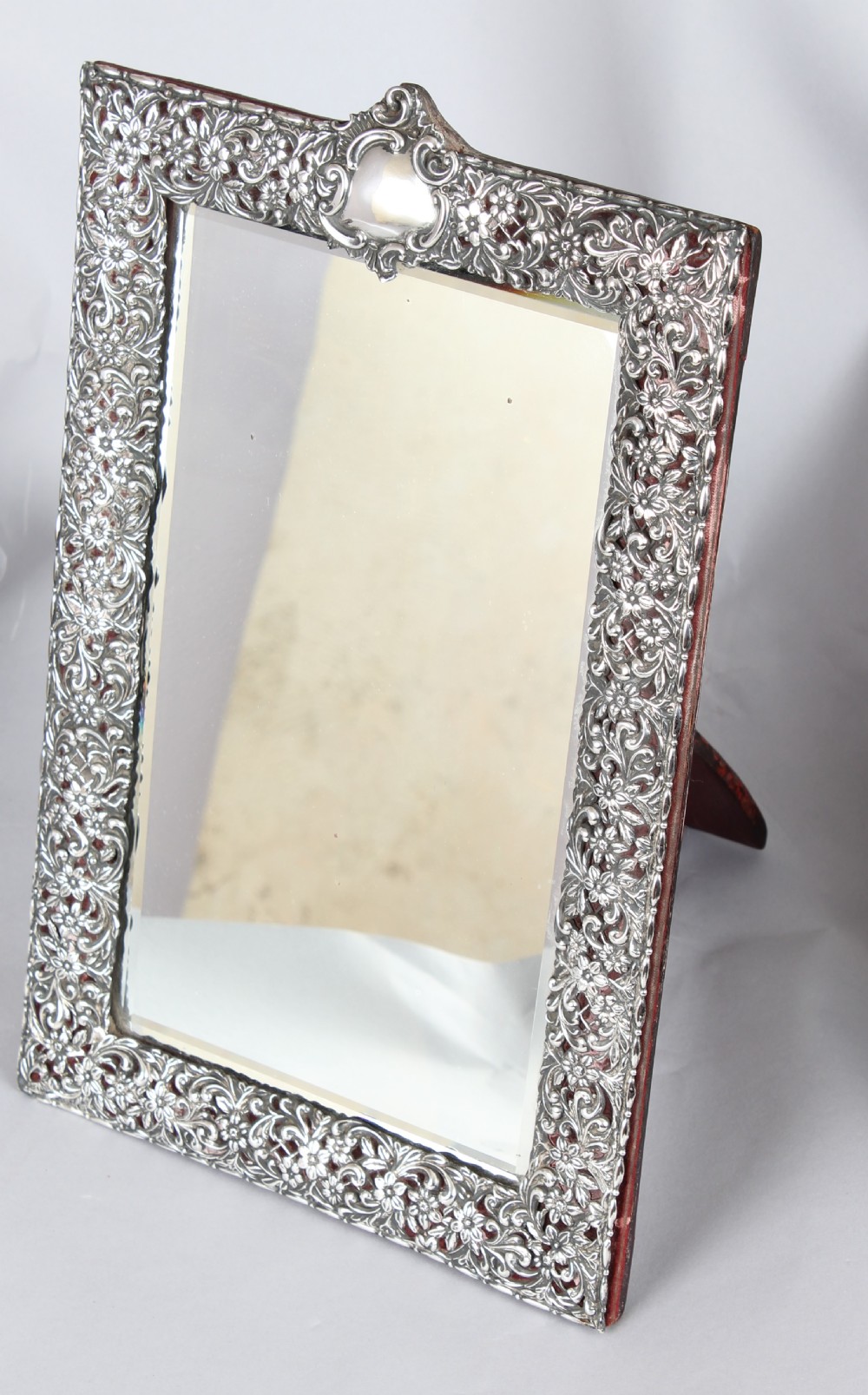 A rectangular Victorian sterling silver easel table mirror with pierced floral scrollwork and a blank crest cartouche. View II