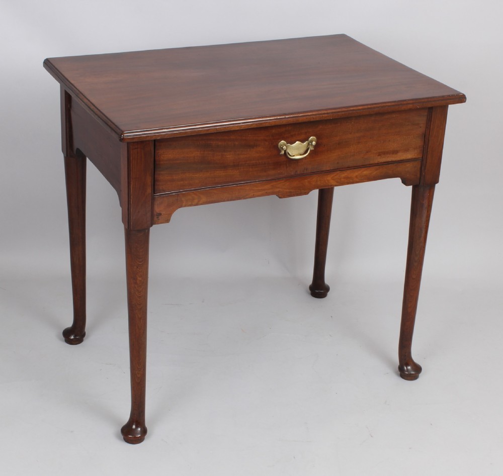A George II Cuban mahogany side table featuring a single drawer with a central brass handle, supported by cabriole legs terminating in pad feet.