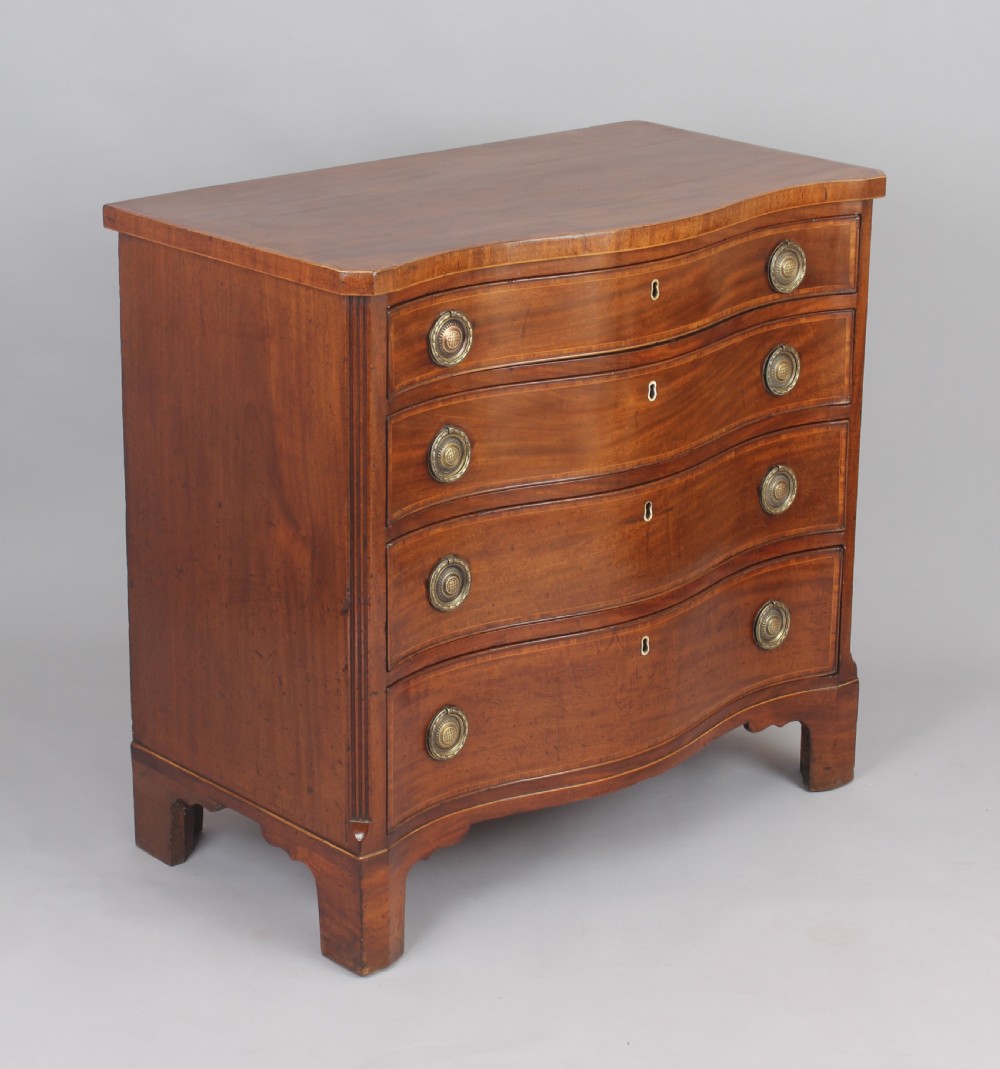 A late eighteenth-century mahogany serpentine chest of drawers featuring four graduated drawers with brass handles resting on bracket feet.