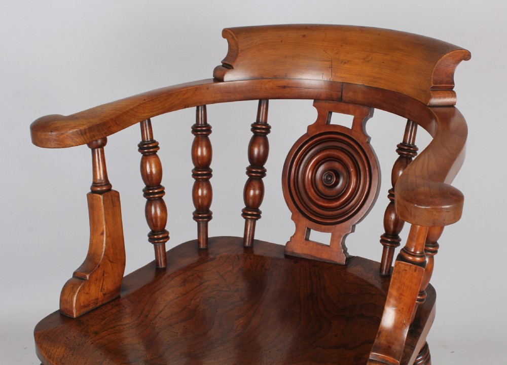 A pair of 19th-century satin birch smokers bow armchairs featuring turned spindles, central carved roundel splats, and shaped wooden seats. View V