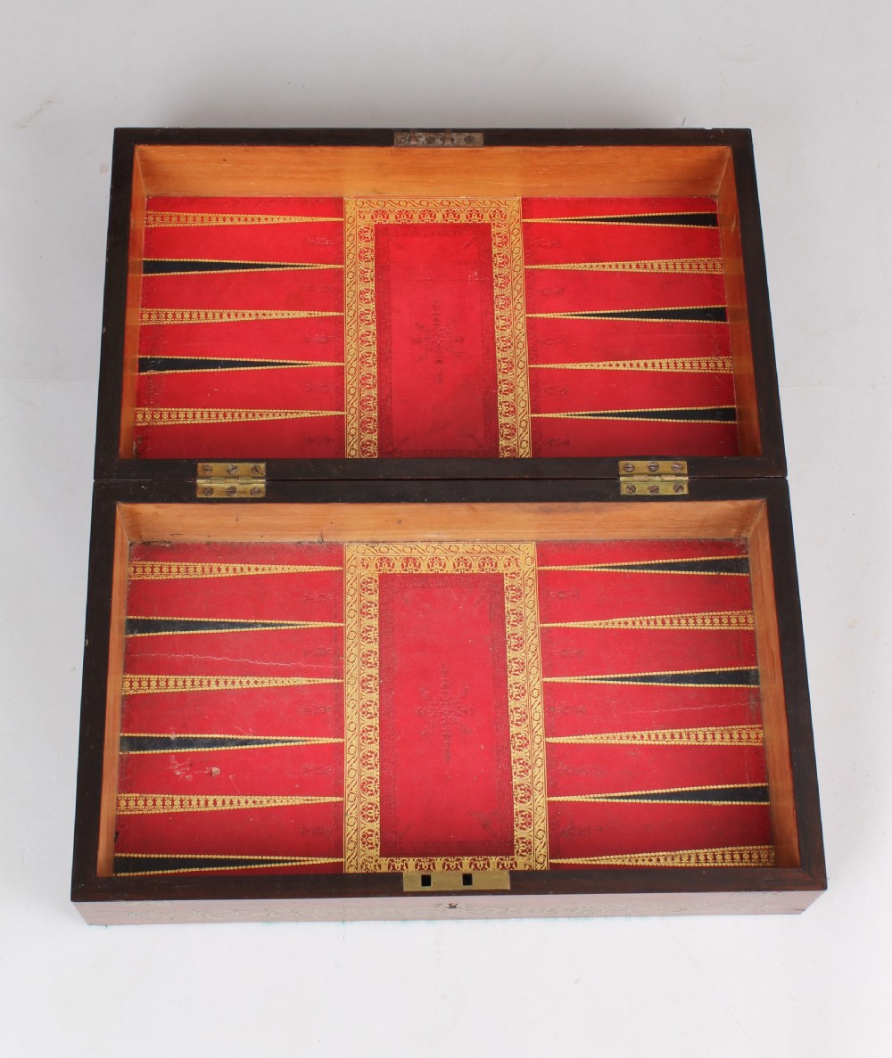 An open early Victorian rosewood games compendium featuring small wooden drawers, a green velvet playing surface, and a red gilt-tooled backgammon interior section. View V