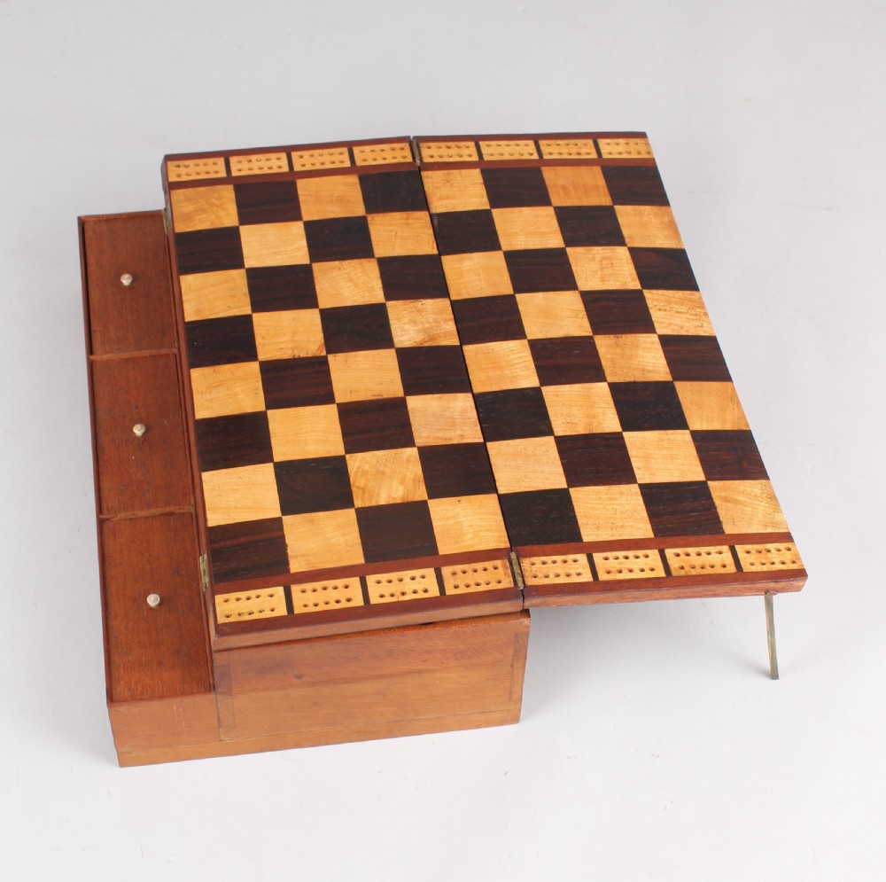 An open early Victorian rosewood games compendium featuring small wooden drawers, a green velvet playing surface, and a red gilt-tooled backgammon interior section. View VIII