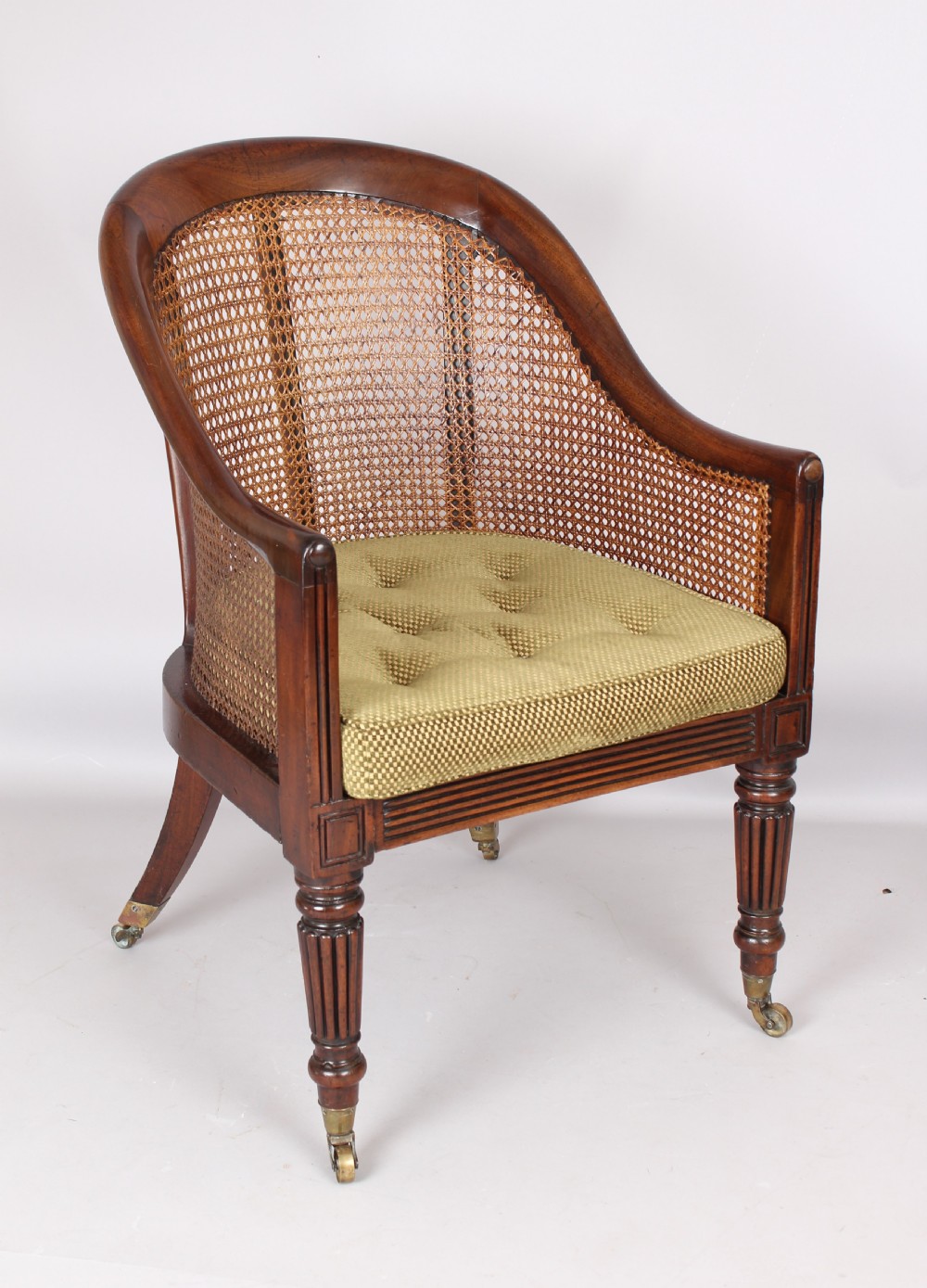An early 19th century mahogany bergere