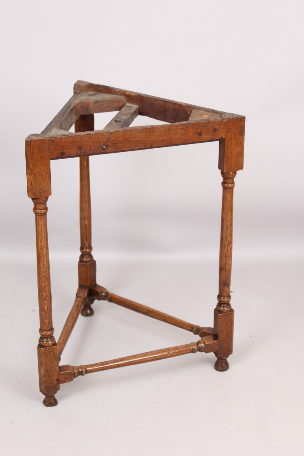 An early 18th-century oak cricket table featuring a triangular top with drop leaves, turned legs, and a triangular stretcher base. View II