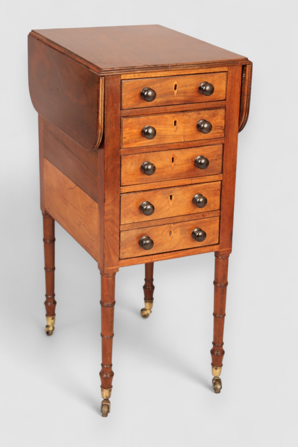 A mahogany drop leaf work table of unusual form 