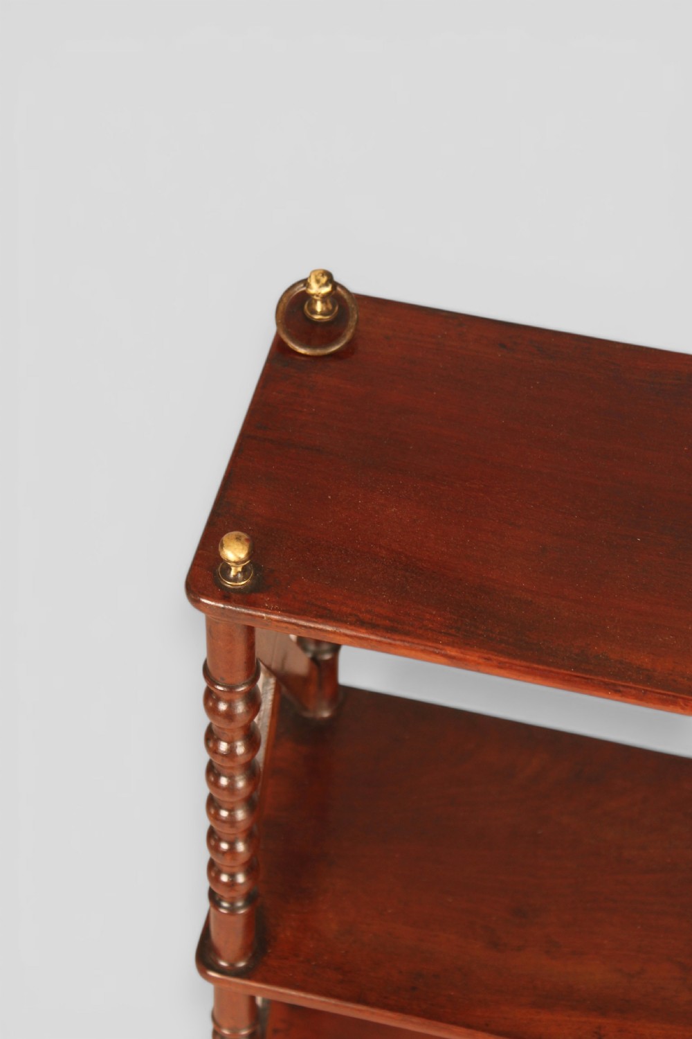 A four-tier dark mahogany hanging shelf unit featuring bobbin-turned vertical posts, X-frame lattice sides, and top brass hanging fixtures. View III