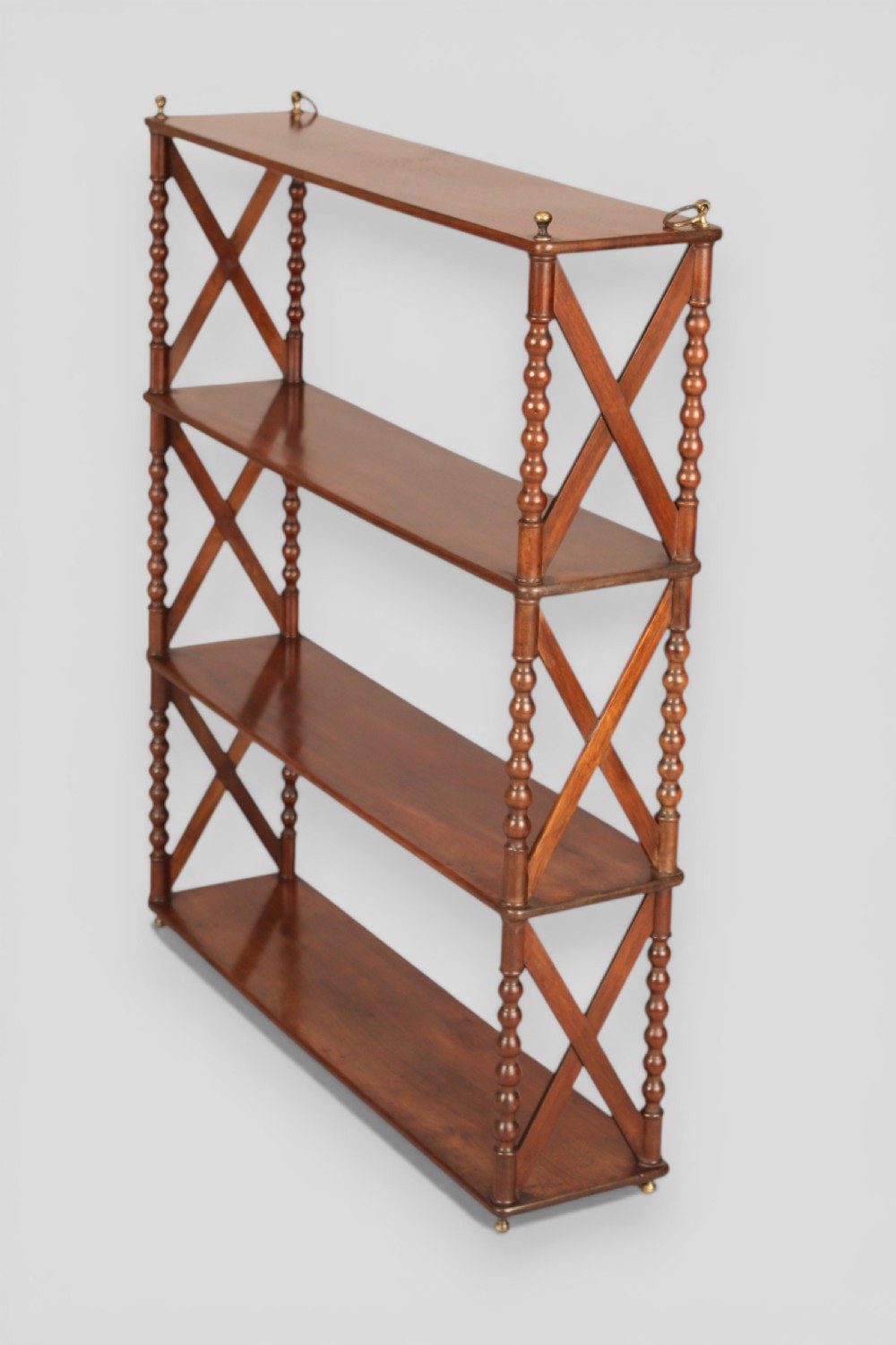 A four-tier dark mahogany hanging shelf unit featuring bobbin-turned vertical posts, X-frame lattice sides, and top brass hanging fixtures. View IV