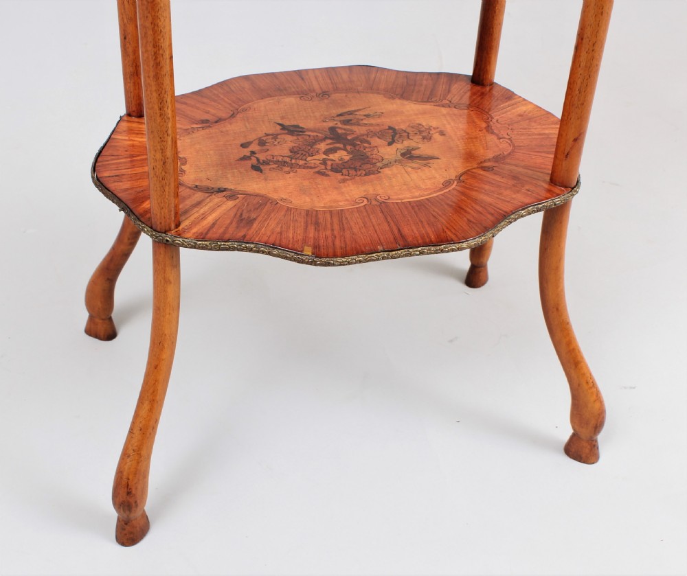 A three-tiered mid 19th century French-style wooden etagere featuring floral marquetry inlays, turned upright supports, brass finials, and a pierced brass gallery on the top shelf. View IV