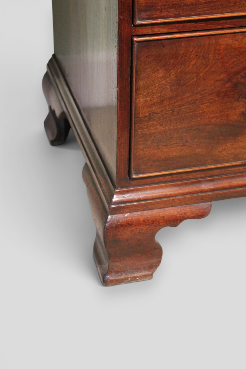 An eighteenth-century mahogany tallboy chest-on-chest featuring a carved frieze, brass swan-neck handles, and bracket feet. View IV