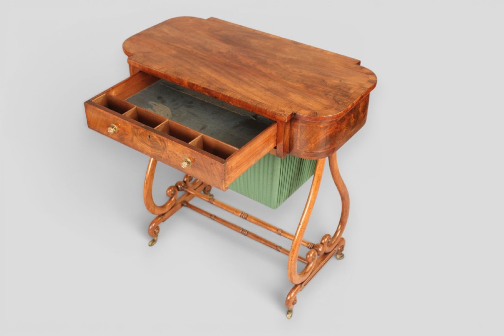 A Regency mahogany work table featuring a single drawer above a pleated green fabric basket, supported by lyre-shaped ends and a double stretcher with castors. View II