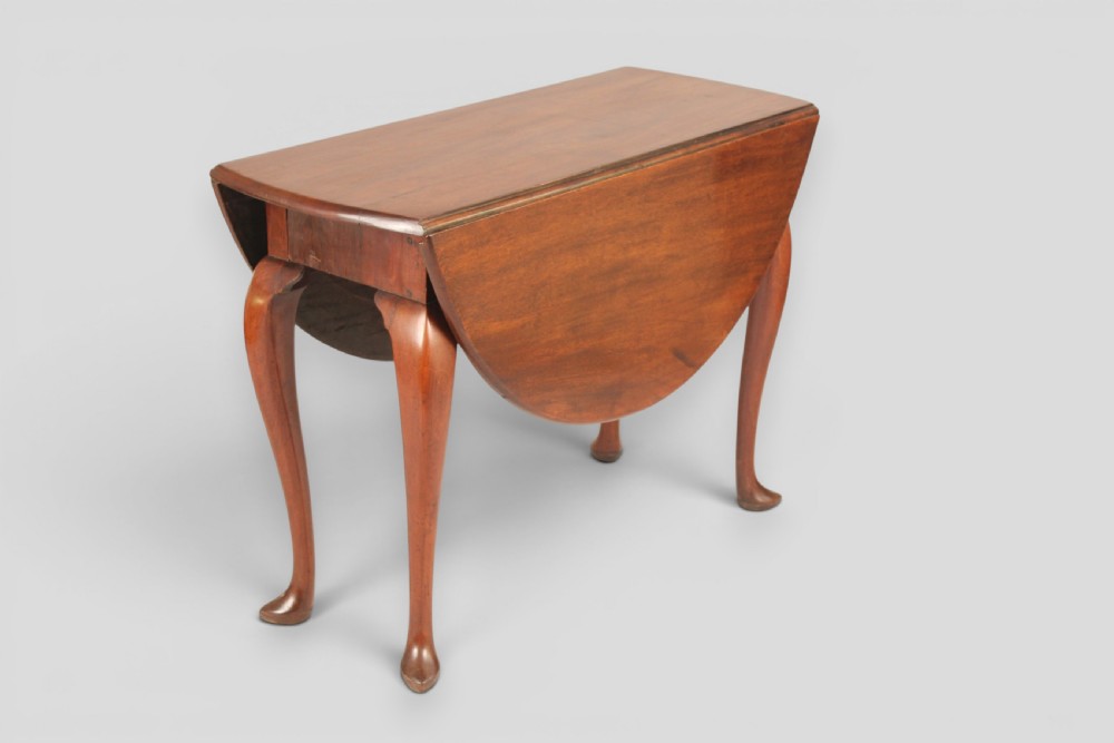 A small mahogany drop-leaf table featuring two hinged circular side flaps and four slender cabriole legs ending in pad feet.