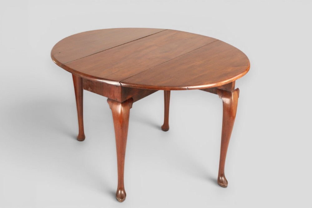 A small mahogany drop-leaf table featuring two hinged circular side flaps and four slender cabriole legs ending in pad feet. View II