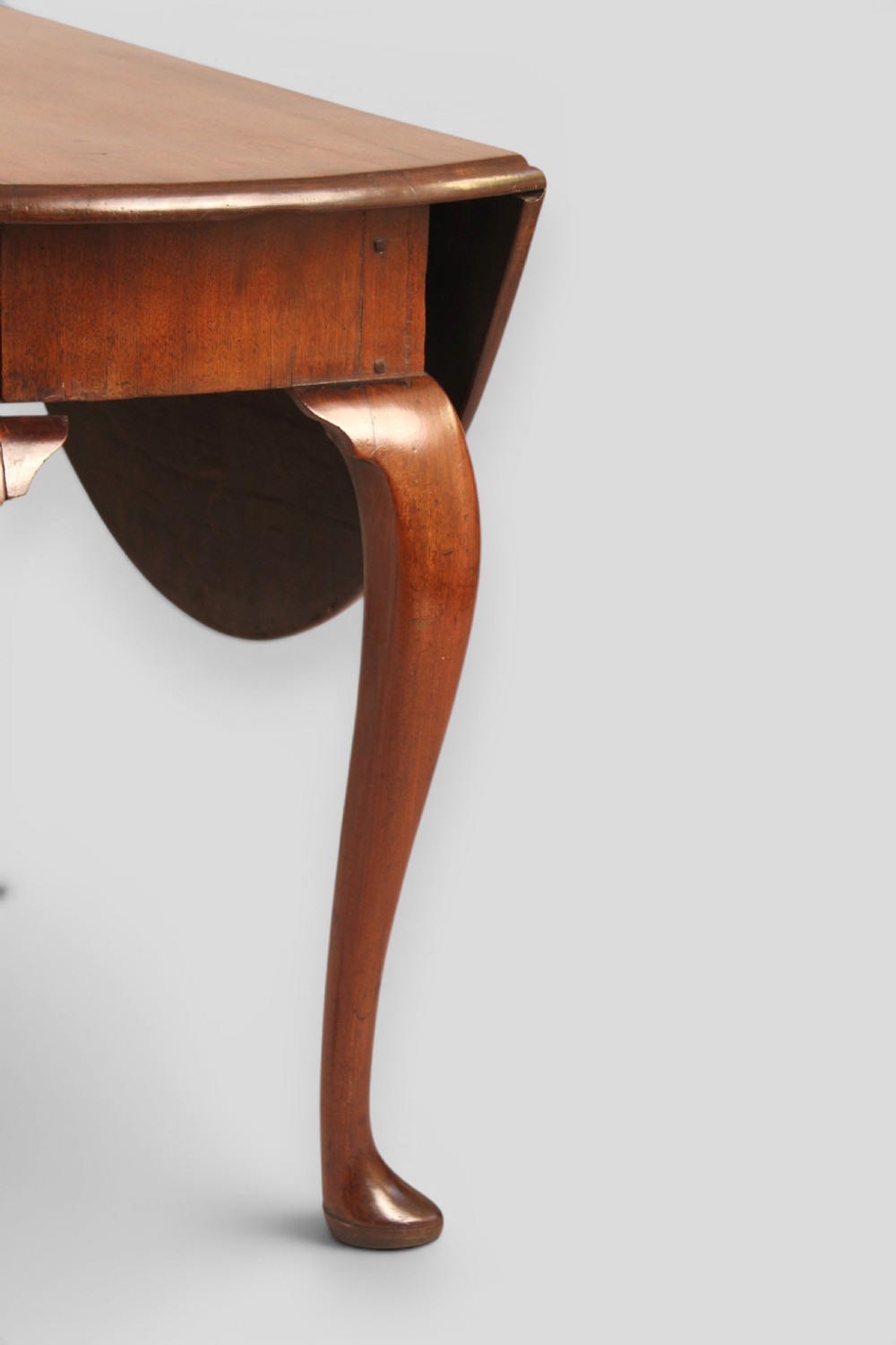A small mahogany drop-leaf table featuring two hinged circular side flaps and four slender cabriole legs ending in pad feet. View IV