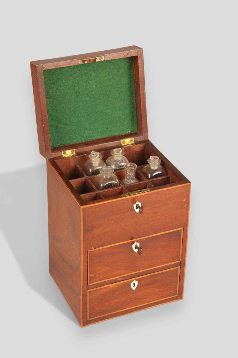 A George III mahogany apothecary box featuring marquetry inlay on the hinged lid and three stacked drawers with shield-shaped bone escutcheons. View III