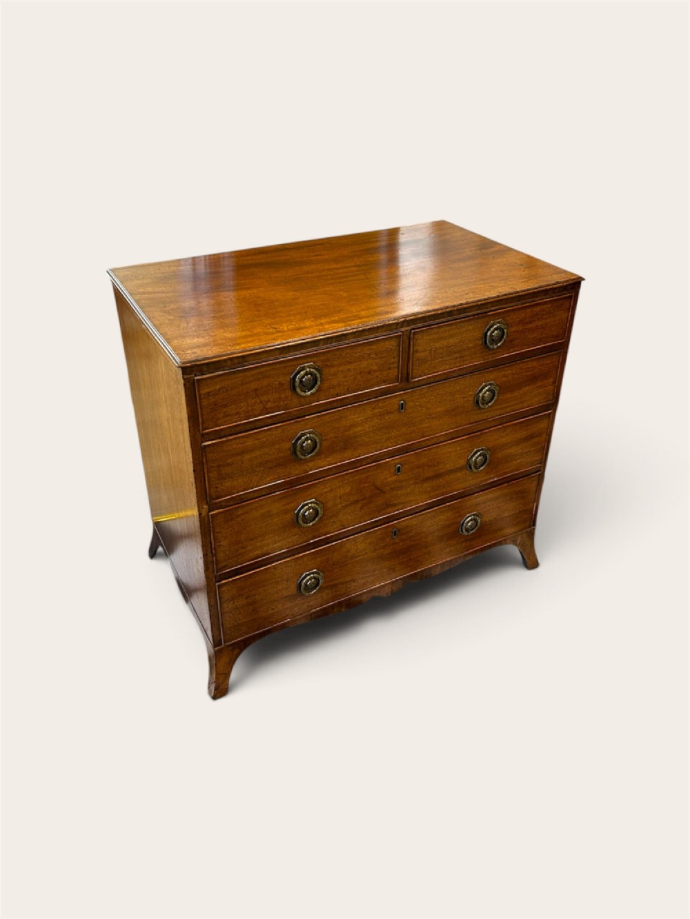 An antique Georgian mahogany chest of drawers featuring two short drawers above three long drawers with brass ring handles and bracket feet.