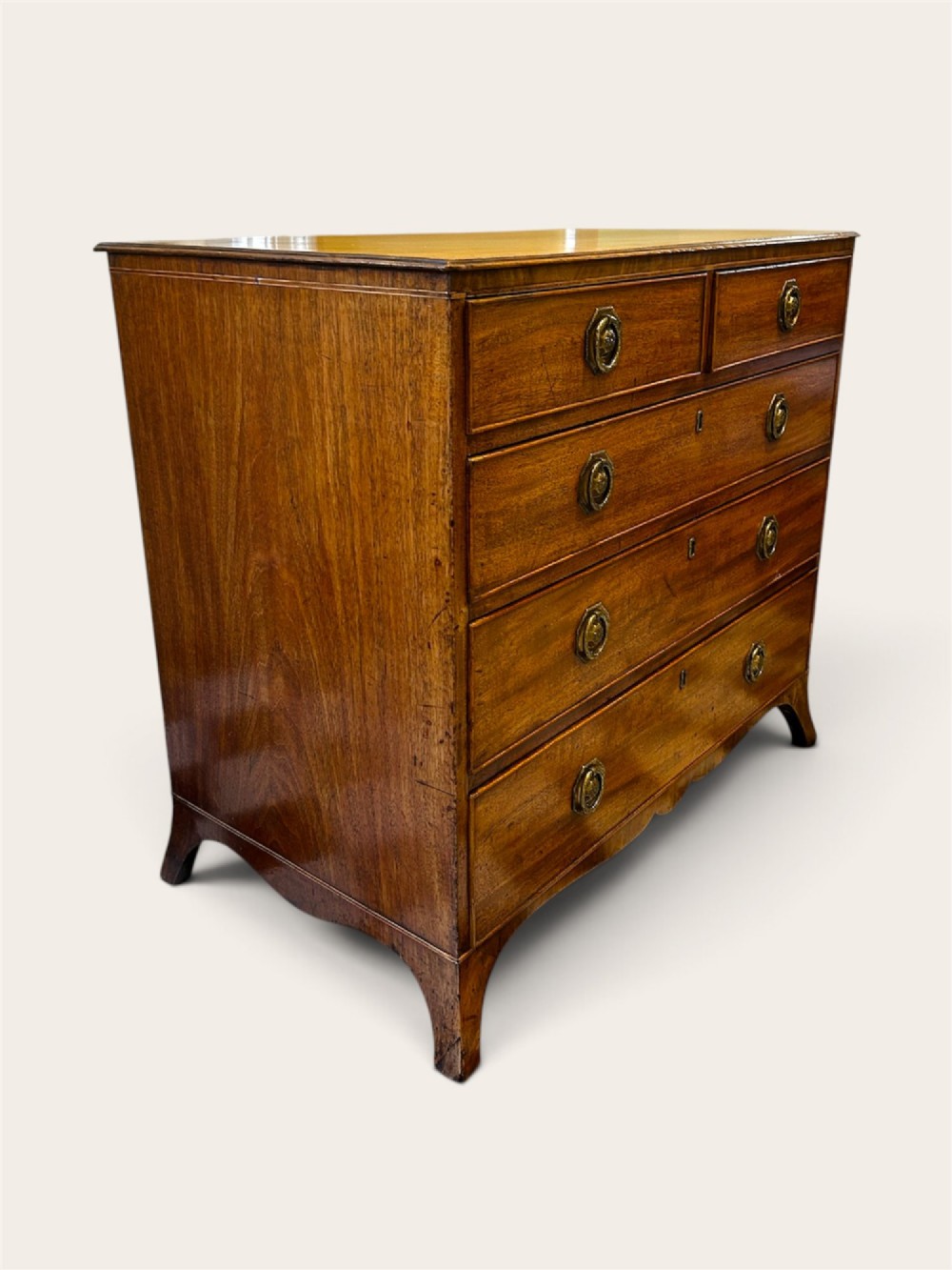 An antique Georgian mahogany chest of drawers featuring two short drawers above three long drawers with brass ring handles and bracket feet. View III