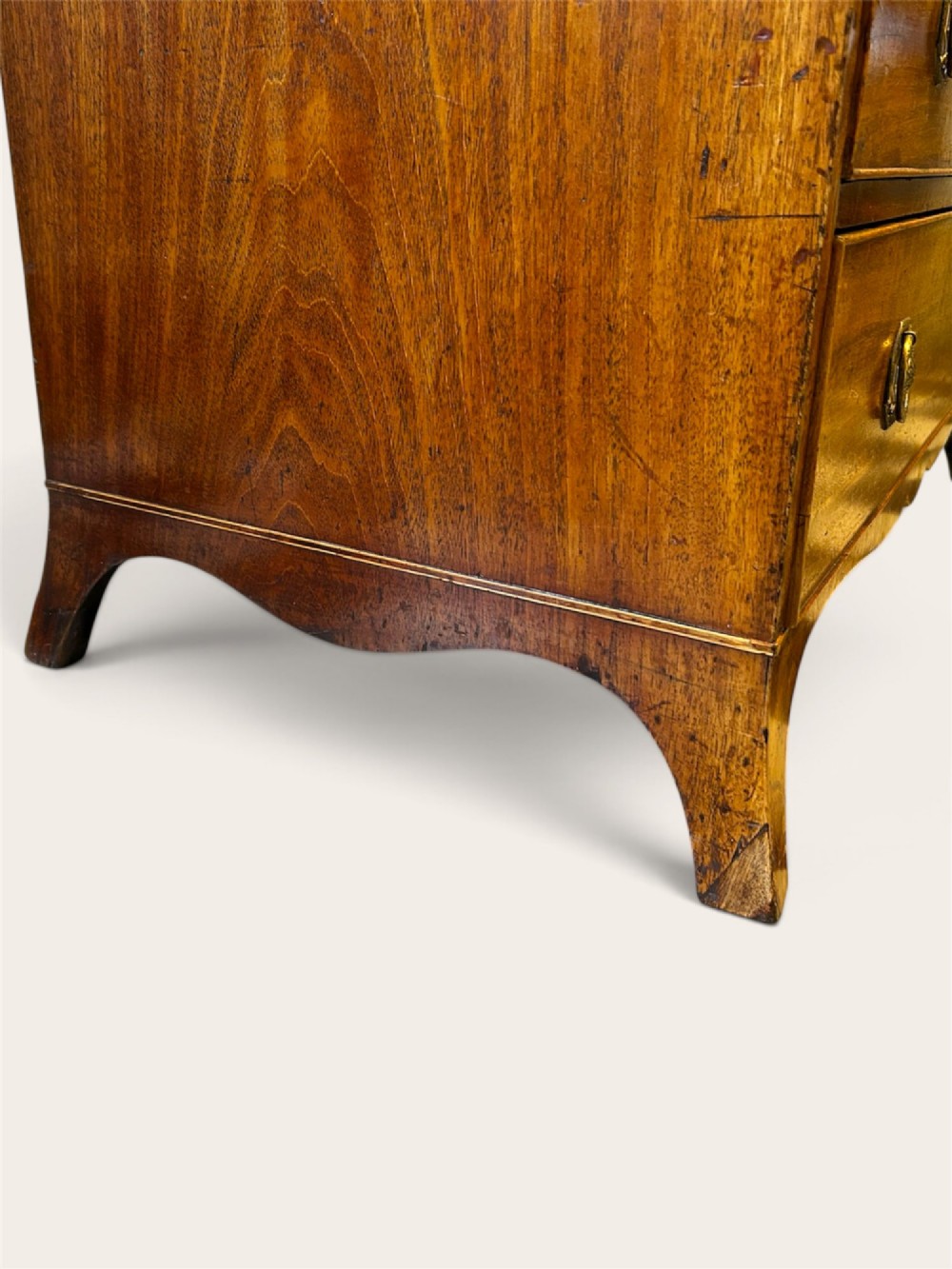 An antique Georgian mahogany chest of drawers featuring two short drawers above three long drawers with brass ring handles and bracket feet. View IV