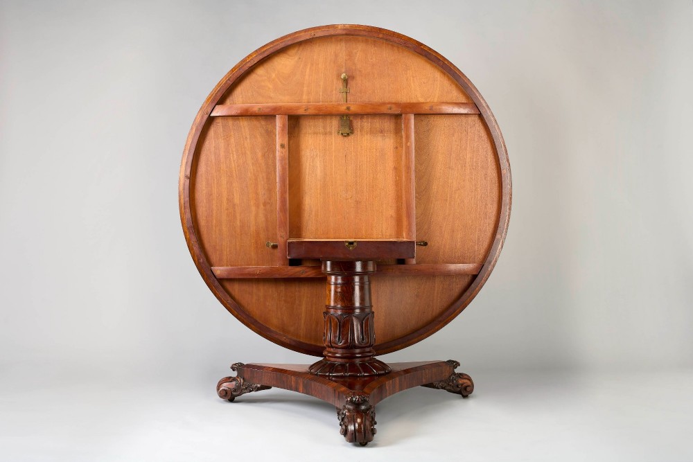 A large George IV circular tilt-top dining or centre table in highly figured book-matched rosewood veneer on a carved triform base. View II