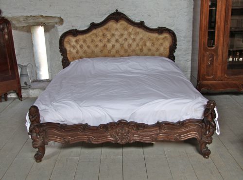 fig 1. Elaborate carved Rococco style dark wood frame upholstered bed with cherubs and matching wall mount bedside cabinets