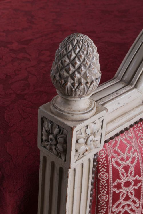 fig 1. A French Louis XVI style king size bedstead featuring a cream painted carved timber frame and red patterned damask upholstered headboard and footboard.