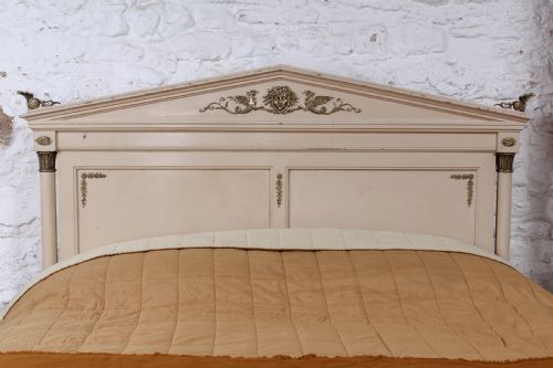 fig 1. An off-white painted French king-size bedstead featuring gilt metal mounts, torch motifs, and carved claw feet.