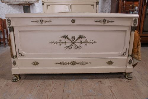 fig 4. An off-white painted French king-size bedstead featuring gilt metal mounts, torch motifs, and carved claw feet.