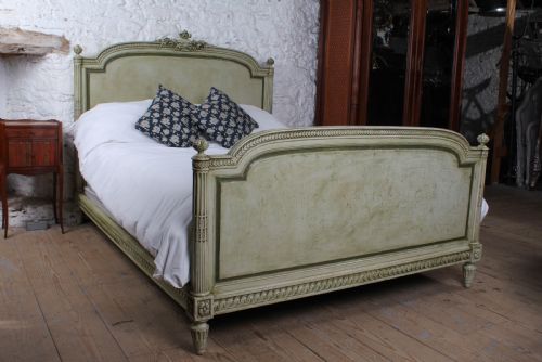 fig 2. A French Louis XVI style king size bedstead in distressed sage green paint with carved fluted posts and decorative molding.
