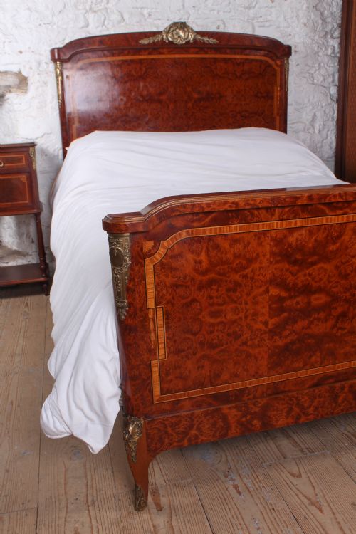 fig 2. A French style kingsize bed frame in warm brown burr mahogany with fruitwood inlay borders and gilt metal corner mounts.