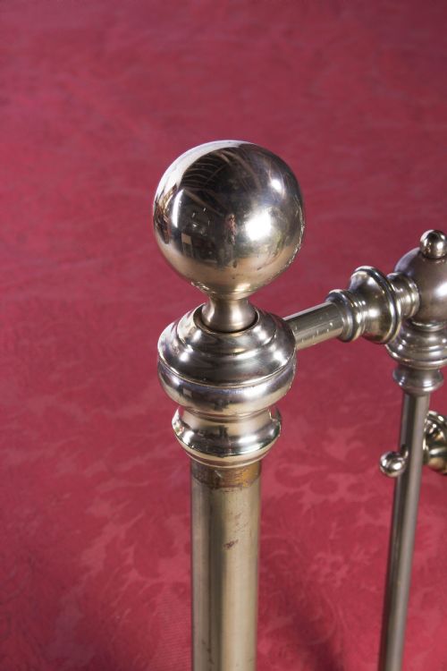fig 2. An antique king-sized brass bedstead featuring turned vertical spindles, corner post finials, and a warm aged patina.
