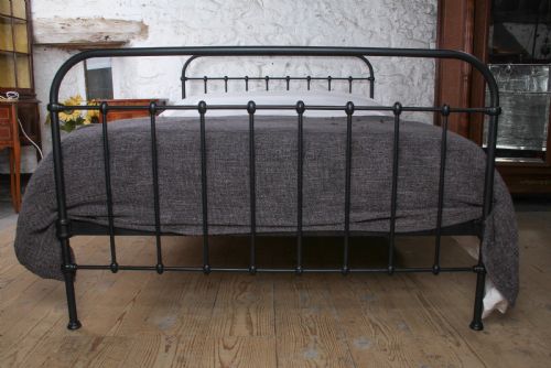 fig 1. A black painted iron double bed frame featuring a vertical spindle headboard and matching footboard.