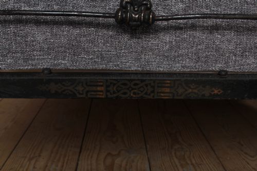 fig 2. An antique dark wrought iron double bed frame featuring arched headboard and footboard rails with decorative cast rosettes.