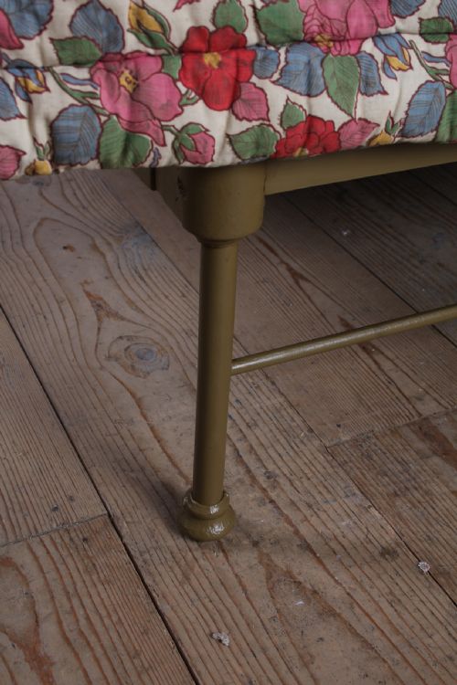 fig 3. A forged iron king-size bedstead featuring an arched looped headboard and an open footless frame.