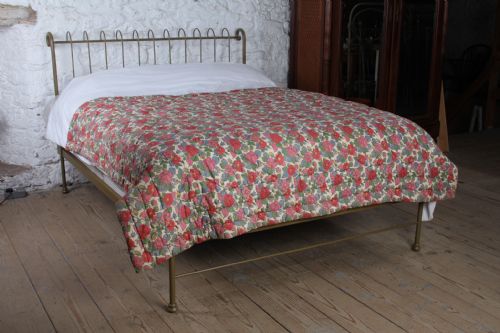 fig 4. A forged iron king-size bedstead featuring an arched looped headboard and an open footless frame.