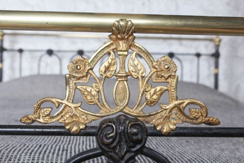 fig 3. A Victorian five-foot king-size bedstead featuring a black japanned cast iron frame with vertical arched spindles, central diamond motifs, and brass top rails with brass finials.