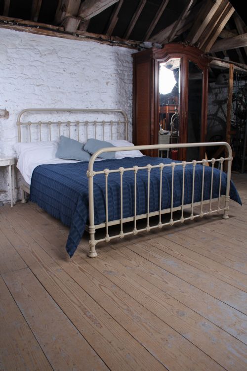 fig 1. A cream-painted French iron super king size bed frame featuring vertical spindles and cast iron ornamental details.