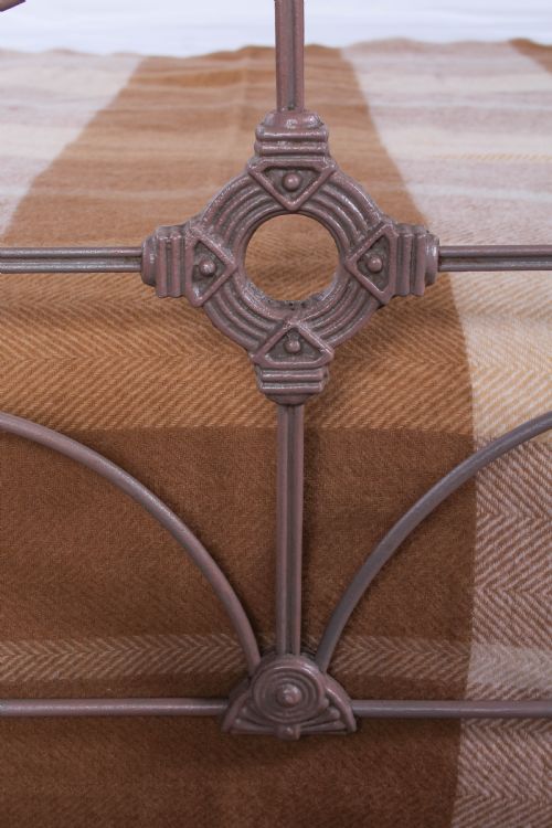 fig 4. An antique Irish double bed frame constructed from painted iron with curved metal scrollwork and decorative cast medallions.