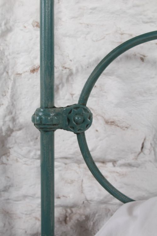 fig 3. A pair of green painted iron single bed frames featuring scrolled Celtic heart motifs on the headboards and low open ends.